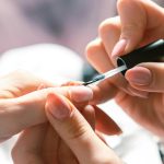 Close-up of a Cosmetician Painting Womans Nails